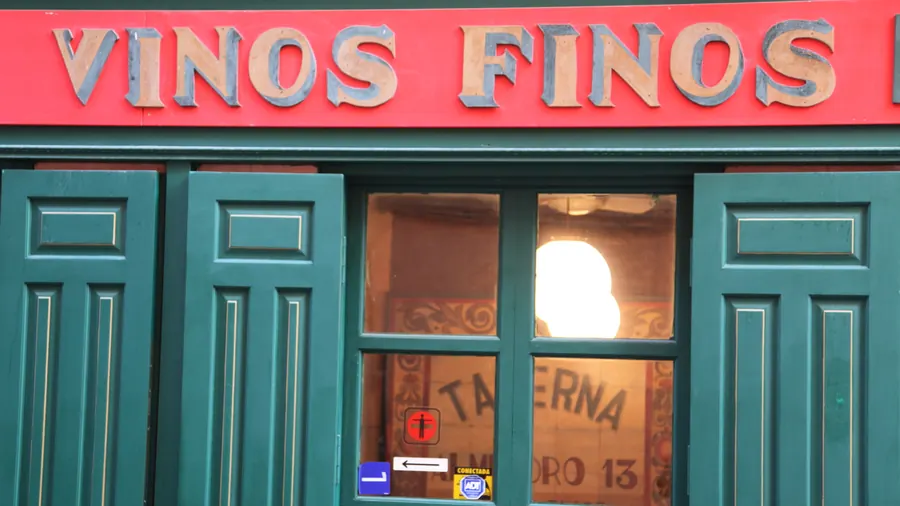 Fachada verde de una taberna de Madrid con el rótulo «Vinos finos»