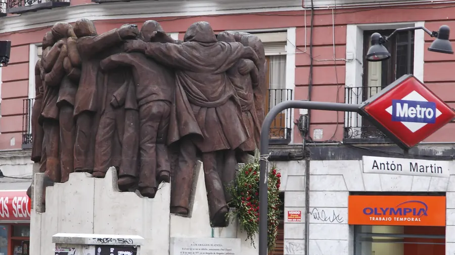 Escultura de bronce El abrazo, de Juan Genovés, junto a la boca de metro de Antón Martín