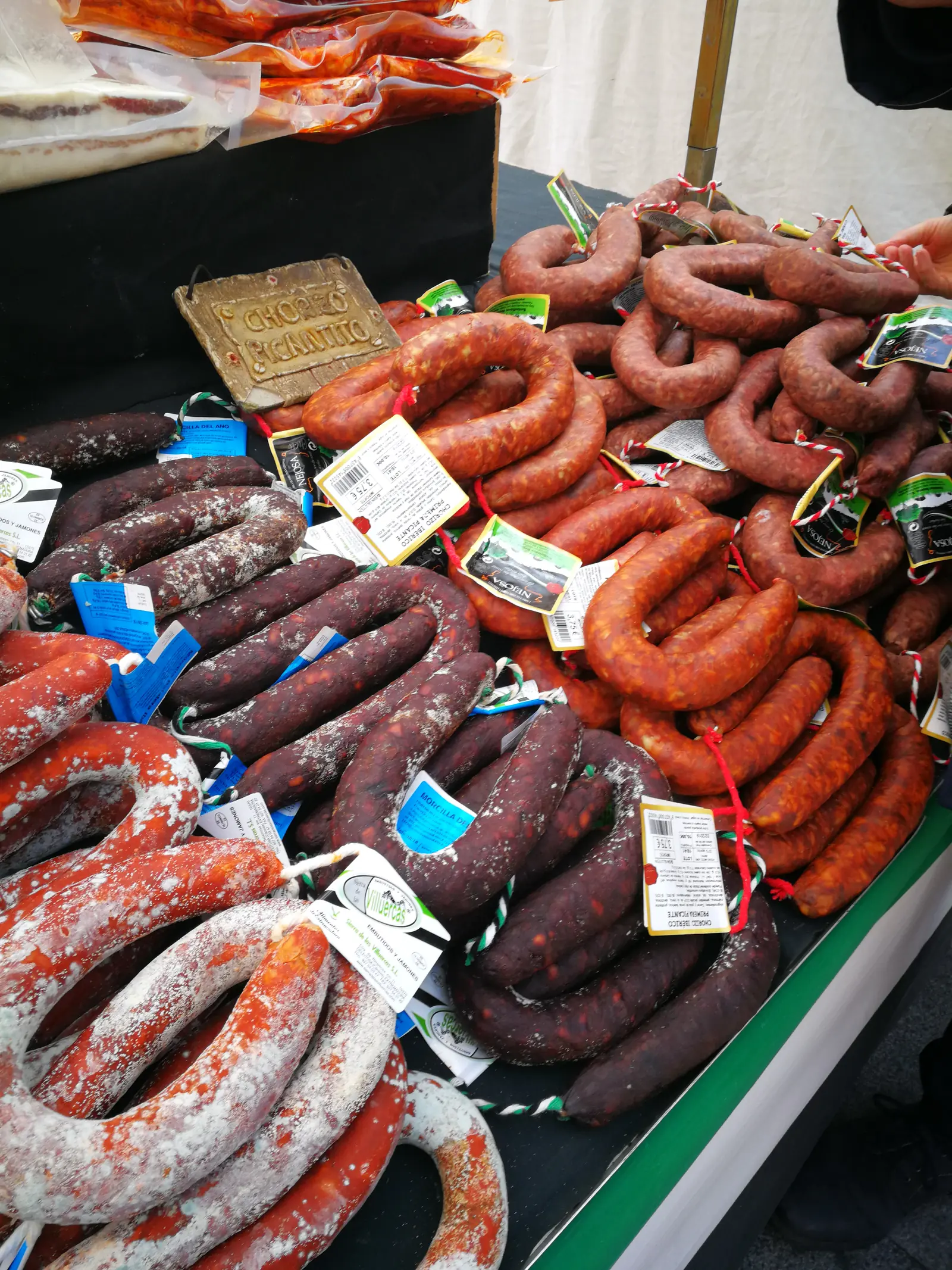 Puesto de embutidos colgados en un mercado de Ávila