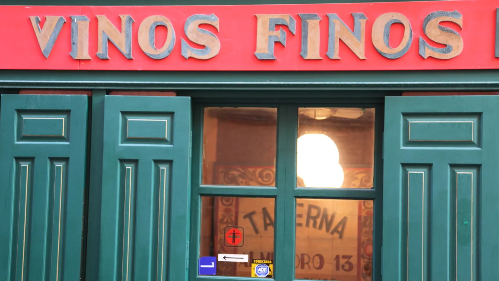 Fachada verde de una taberna de Madrid con el rótulo «Vinos finos»