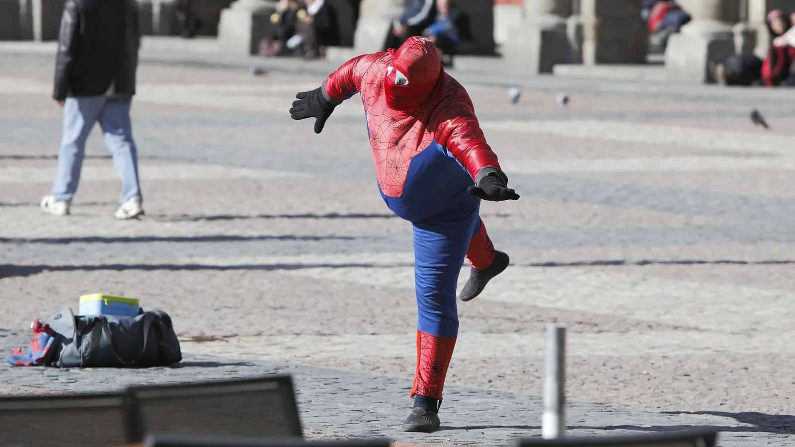 Una persona disfrazada de Spiderman hace una pose en la Plaza Mayor de Madrid