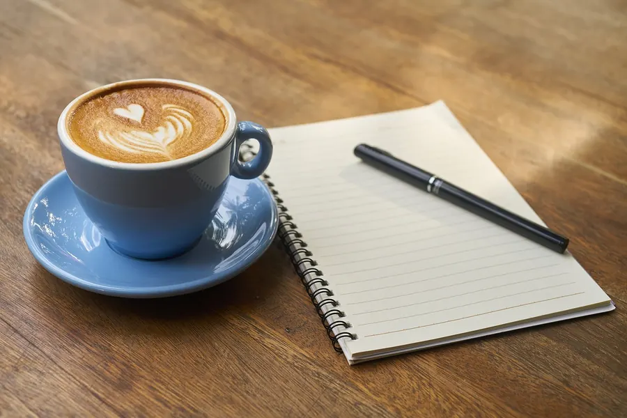 Taza de café junto a libros de español