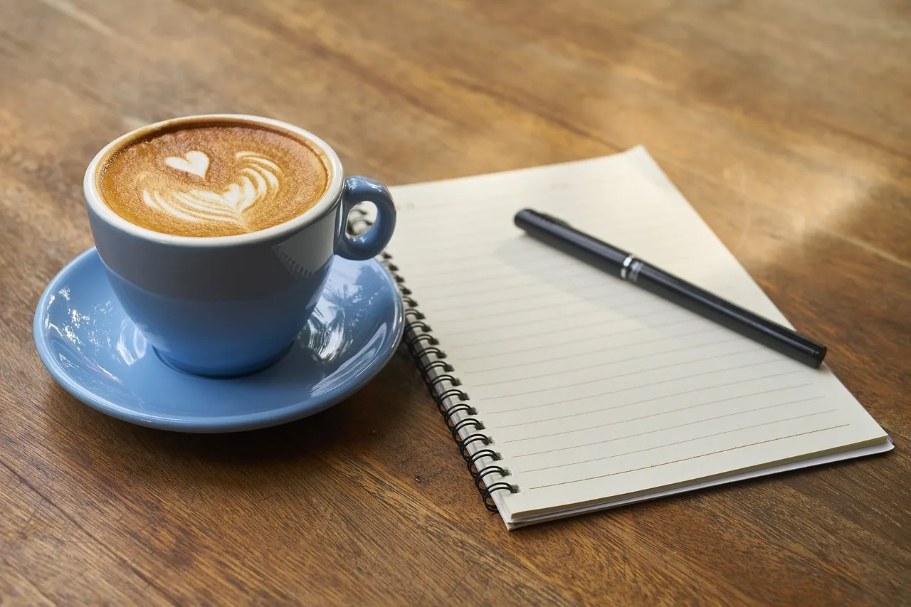 Taza de café junto a libros de español